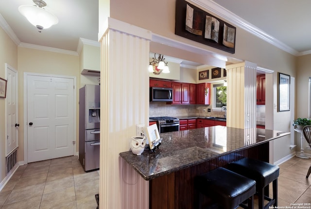 kitchen featuring crown molding, a sink, stainless steel appliances, light tile patterned floors, and reddish brown cabinets