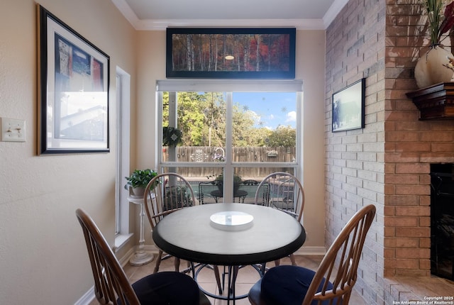 dining room with crown molding, baseboards, and a fireplace