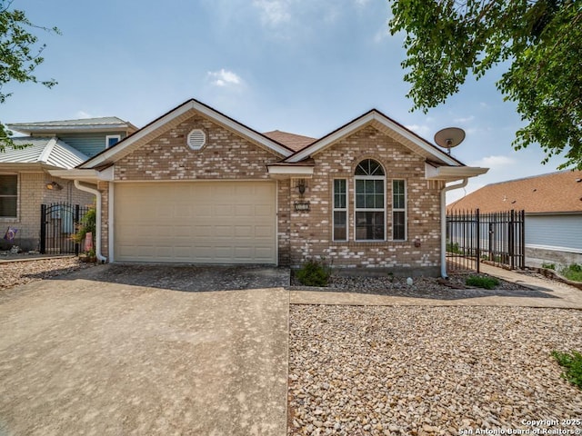 view of front of house featuring concrete driveway, brick siding, an attached garage, and fence