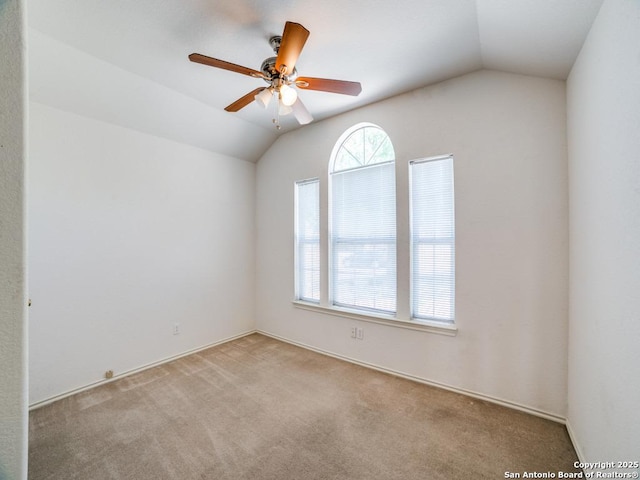 carpeted spare room with ceiling fan and lofted ceiling