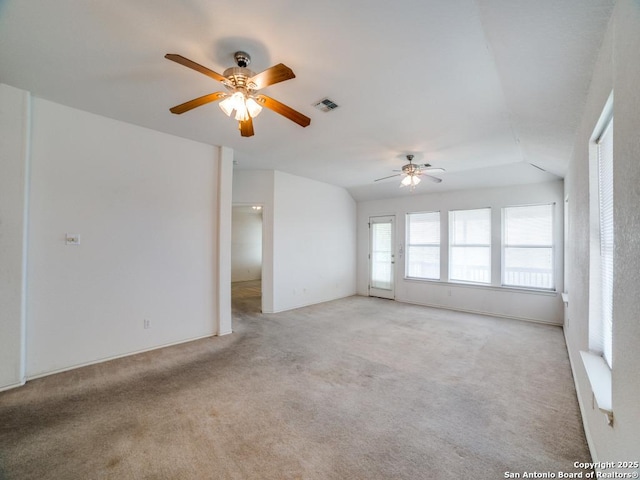 empty room featuring ceiling fan, light carpet, lofted ceiling, and visible vents