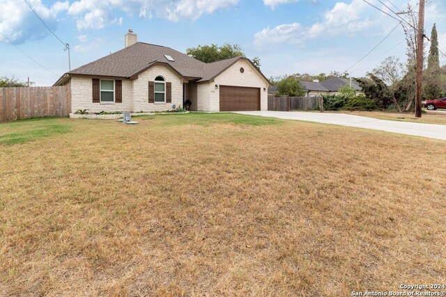 15742 Chippewa Blvd, Selma, TX 78154 - view of front of house with a front lawn, fence, a chimney, an attached garage, and driveway