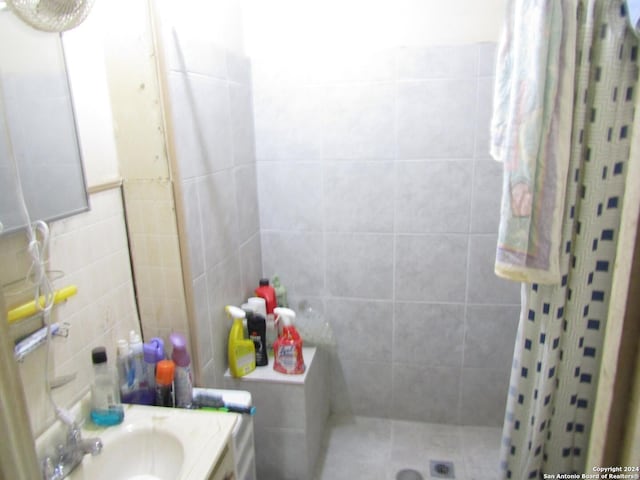 217 Lancaster, San Antonio, TX 78214 - bathroom with tile walls, vanity, and tiled shower