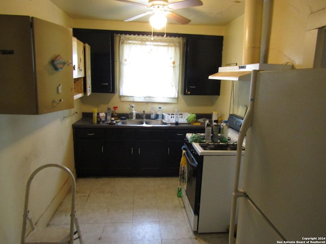 217 Lancaster, San Antonio, TX 78214 - kitchen featuring a sink, dark cabinetry, freestanding refrigerator, and gas range oven