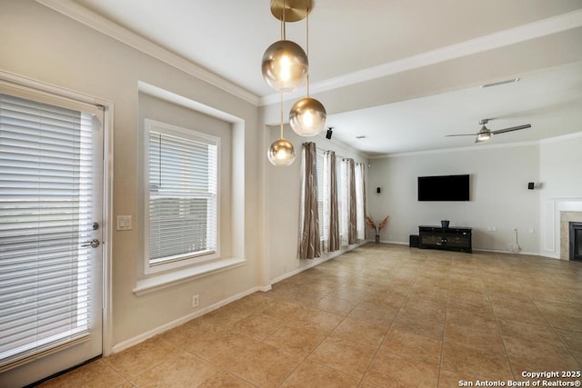unfurnished living room with a ceiling fan, a tiled fireplace, light tile patterned floors, baseboards, and ornamental molding