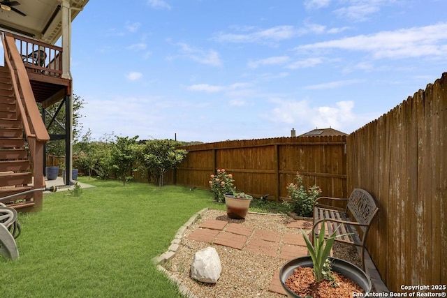 view of yard featuring stairway, a wooden deck, and a fenced backyard