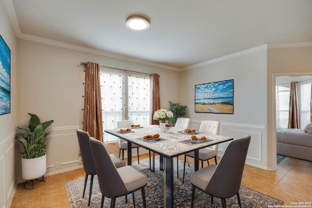 dining space with crown molding, a decorative wall, and light tile patterned floors