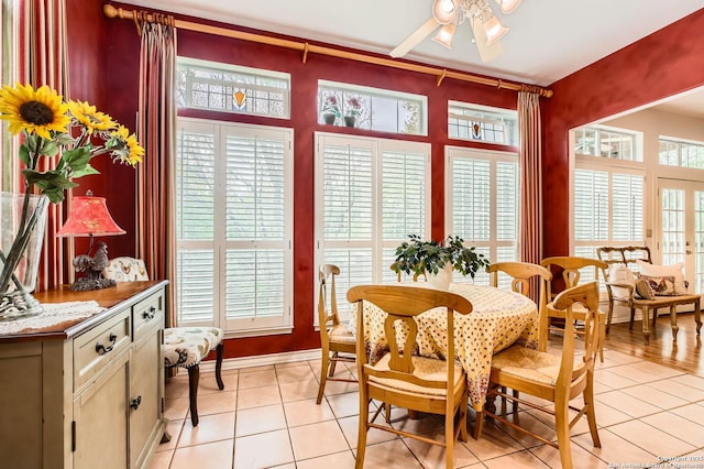 dining space featuring baseboards, ceiling fan, and light tile patterned floors