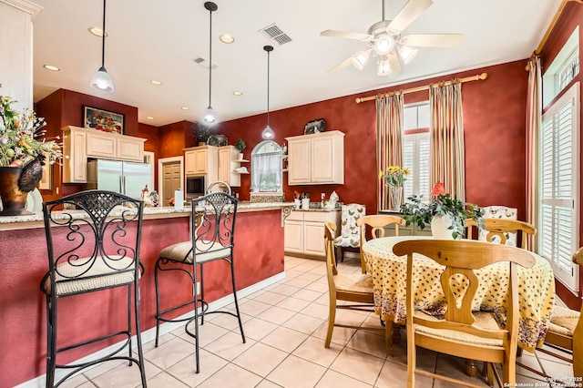 kitchen featuring stainless steel fridge, plenty of natural light, a ceiling fan, and decorative light fixtures