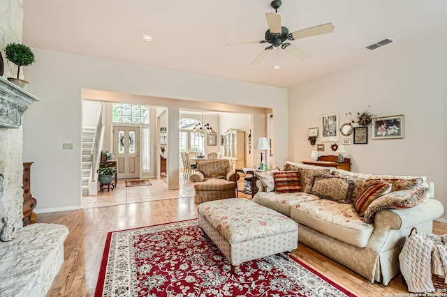 living room with recessed lighting, visible vents, light wood-style flooring, and ceiling fan with notable chandelier