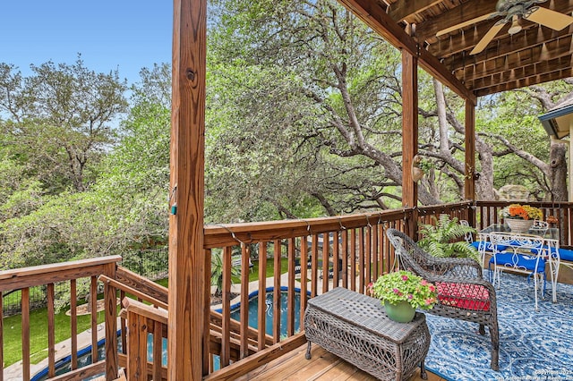 deck featuring a ceiling fan and an outdoor pool