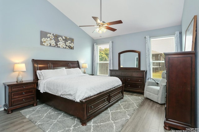 bedroom with ceiling fan, lofted ceiling, and light wood-type flooring
