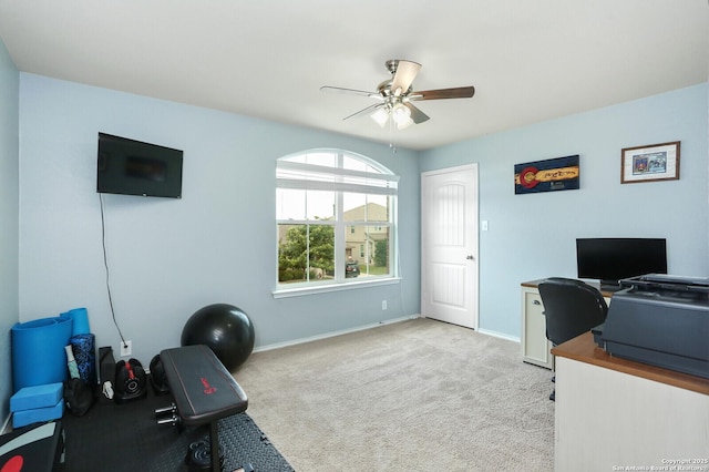 office featuring baseboards, ceiling fan, and light colored carpet