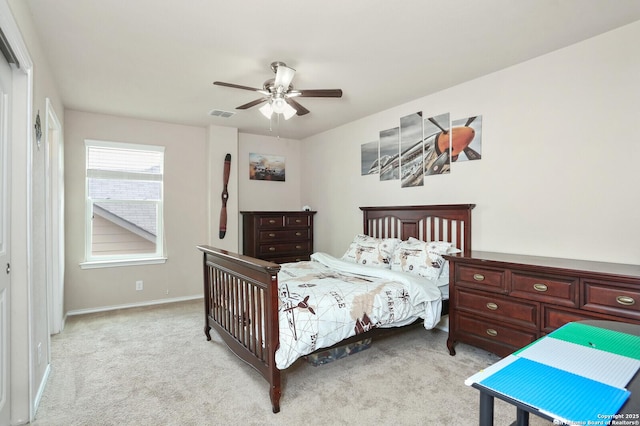 bedroom with baseboards, light carpet, a ceiling fan, and visible vents