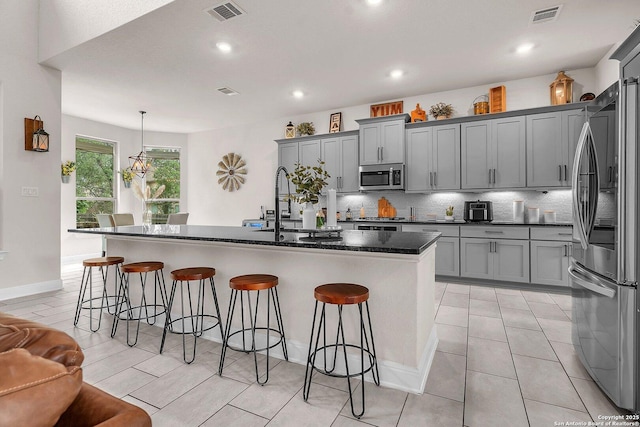kitchen featuring stainless steel appliances, a sink, visible vents, and gray cabinets