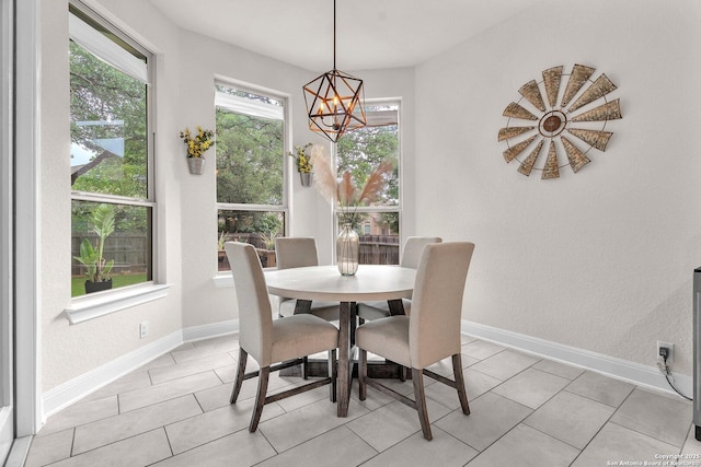 dining space featuring baseboards and a notable chandelier