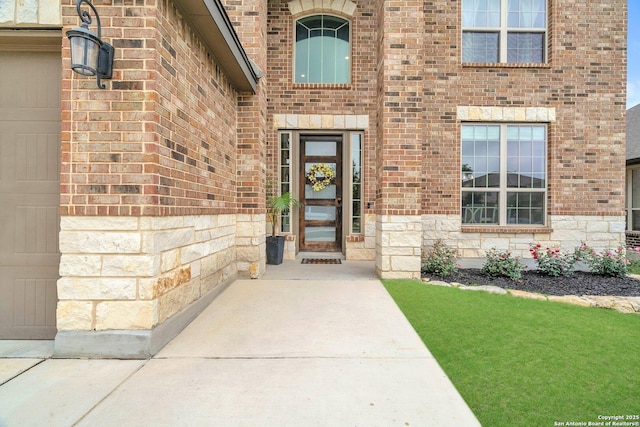 doorway to property featuring brick siding and stone siding