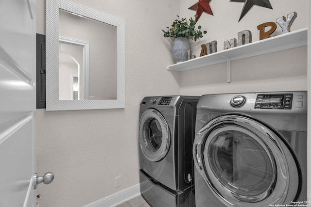 washroom featuring baseboards, laundry area, and washer and clothes dryer