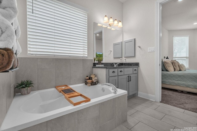 ensuite bathroom with vanity, connected bathroom, and a bath