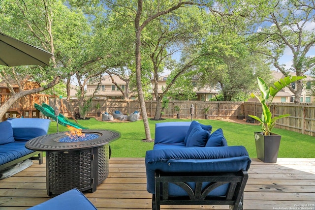 deck featuring a fenced backyard, an outdoor living space with a fire pit, a yard, and a playground