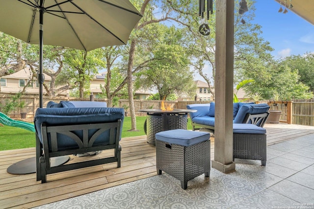deck with outdoor lounge area, a fenced backyard, and a playground