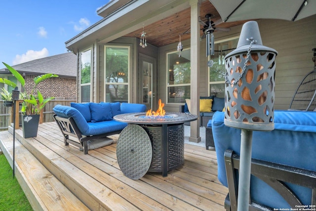 wooden terrace with an outdoor living space with a fire pit