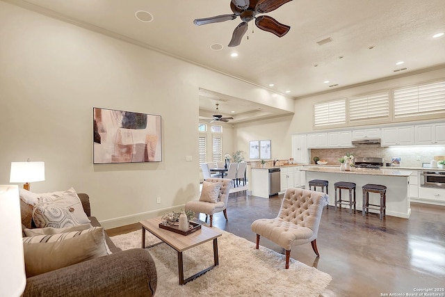 living room with crown molding, finished concrete flooring, baseboards, ceiling fan, and recessed lighting