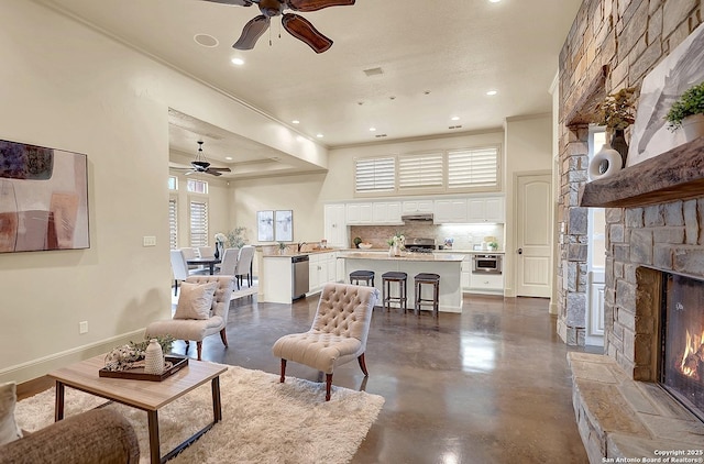 living room featuring recessed lighting, a ceiling fan, concrete flooring, and a fireplace