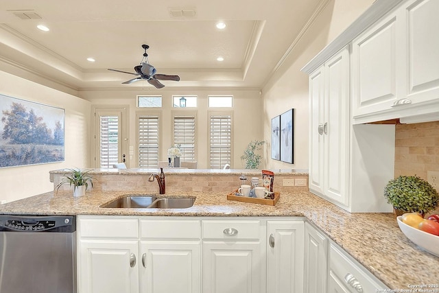 kitchen with ceiling fan, visible vents, stainless steel dishwasher, a sink, and a raised ceiling