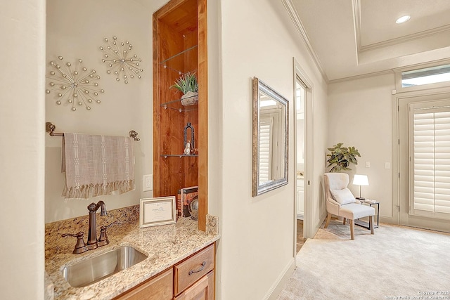 interior space with baseboards, ornamental molding, a sink, and light carpet