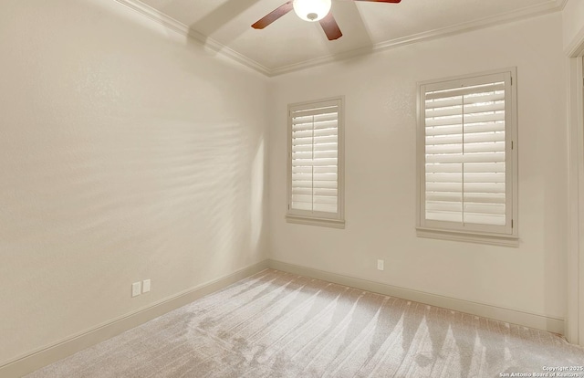unfurnished room with crown molding, carpet floors, baseboards, and a ceiling fan
