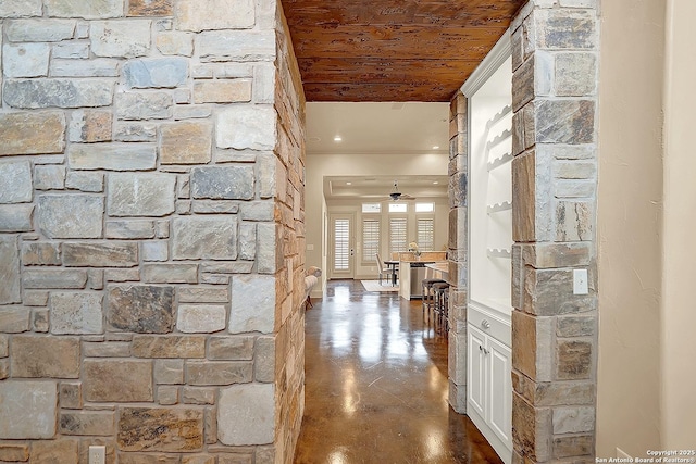 corridor featuring wood ceiling, recessed lighting, and finished concrete floors