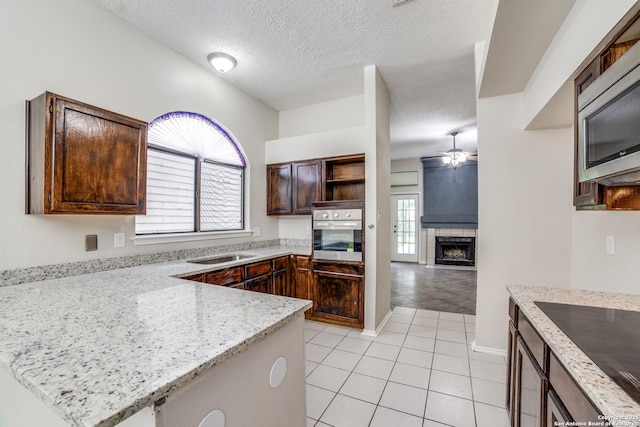 10210 Apricot Fld, San Antonio, TX 78245 - kitchen with ceiling fan, a textured ceiling, appliances with stainless steel finishes, open shelves, and light tile patterned floors
