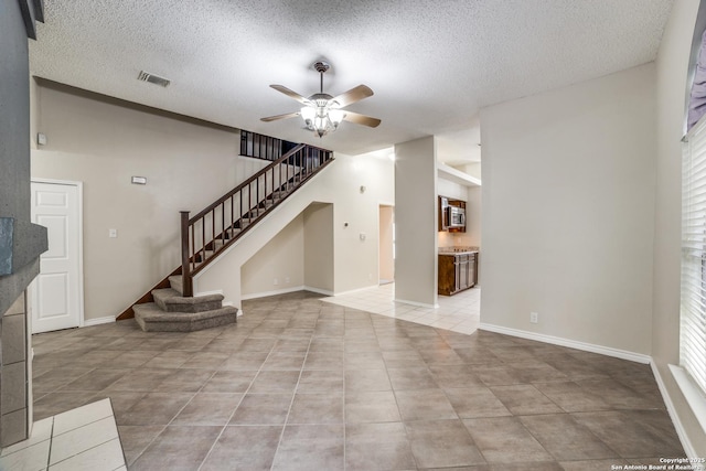 10210 Apricot Fld, San Antonio, TX 78245 - unfurnished living room with visible vents, ceiling fan, light tile patterned floors, and stairway