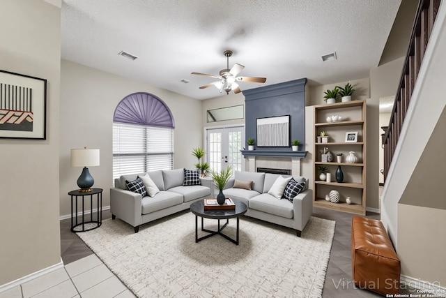 10210 Apricot Fld, San Antonio, TX 78245 - living area with ceiling fan, a textured ceiling, french doors, stairs, and baseboards