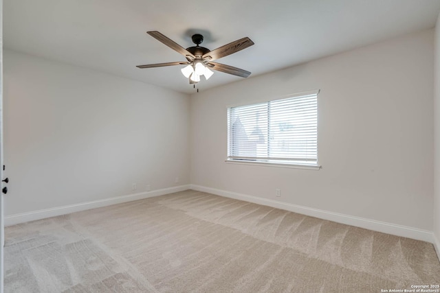 empty room with baseboards, ceiling fan, and light carpet