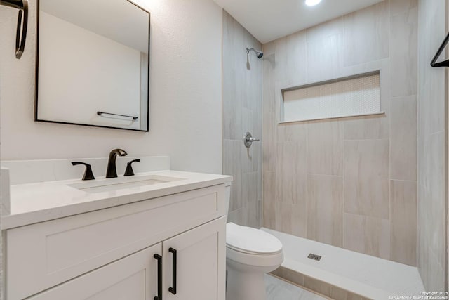 bathroom featuring toilet, recessed lighting, tiled shower, and vanity