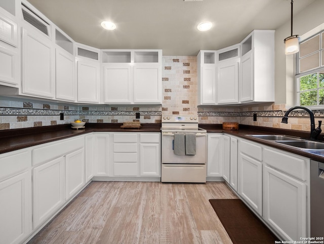 kitchen featuring visible vents, dark countertops, white electric range, a sink, and white cabinets