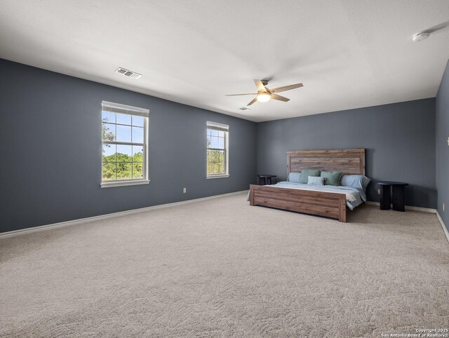 carpeted bedroom featuring a ceiling fan, baseboards, and visible vents