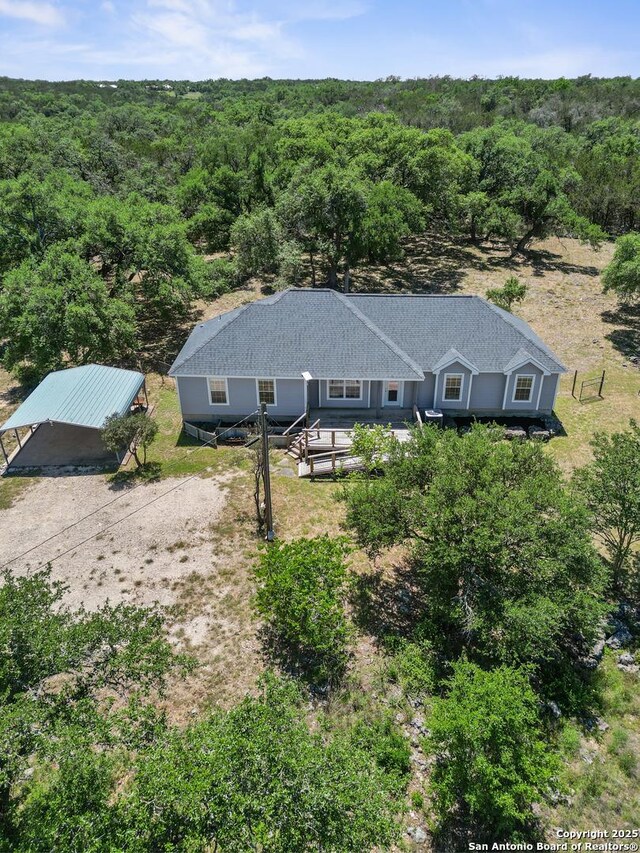 birds eye view of property featuring a view of trees