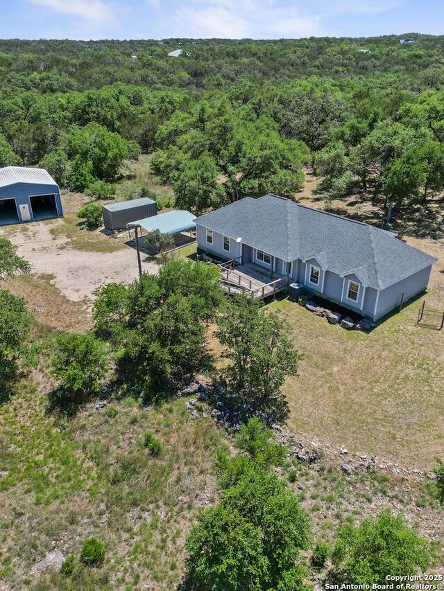 drone / aerial view featuring a wooded view