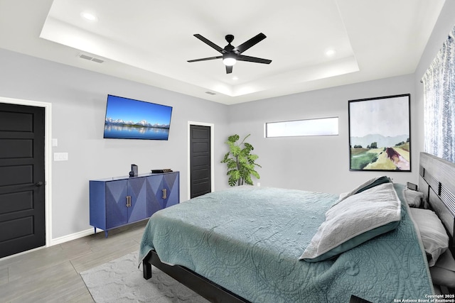 bedroom with ceiling fan, a raised ceiling, recessed lighting, baseboards, and visible vents
