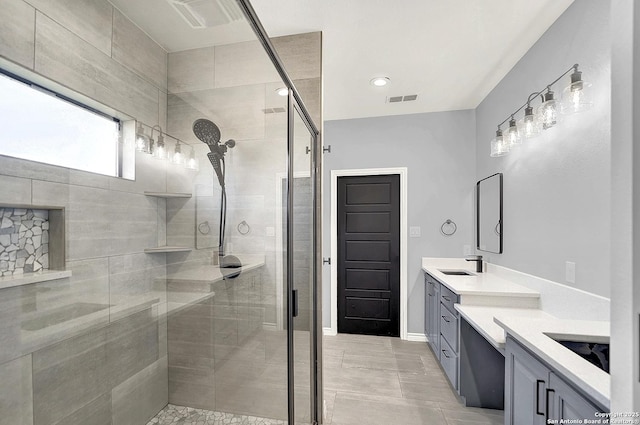full bathroom featuring vanity, a stall shower, and visible vents