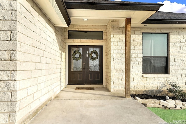 property entrance with french doors and a shingled roof