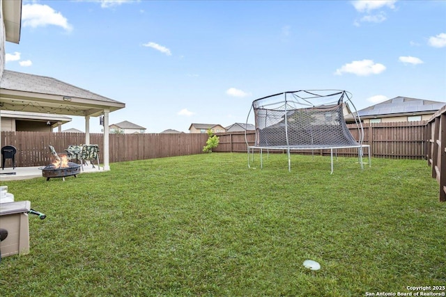 2927 Lindenwood, San Antonio, TX 78245 - view of yard featuring a fenced backyard, a patio area, a trampoline, and an outdoor fire pit