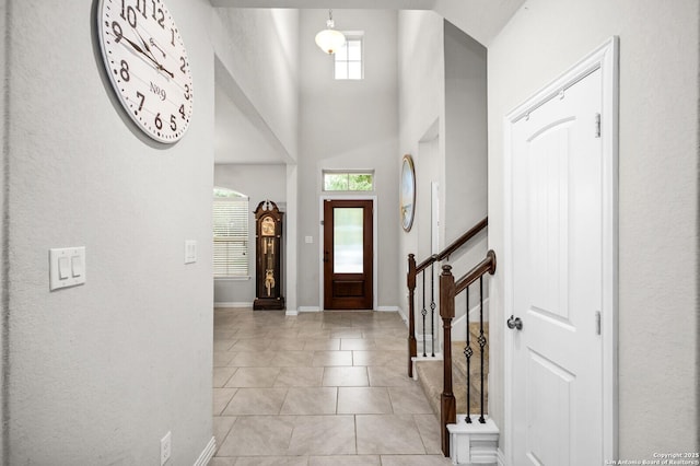 14447 Costa Leon, San Antonio, TX 78245 - entryway with light tile patterned flooring, a high ceiling, baseboards, and stairs