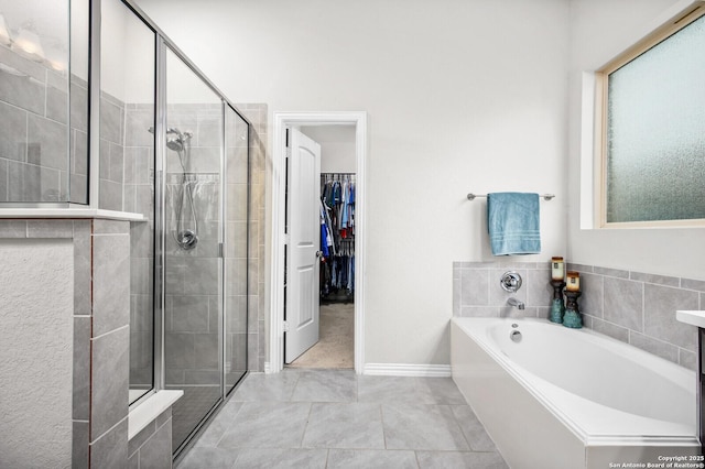 14447 Costa Leon, San Antonio, TX 78245 - full bath with a garden tub, a shower stall, a spacious closet, tile patterned floors, and baseboards