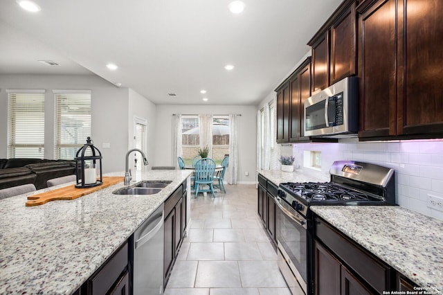 14447 Costa Leon, San Antonio, TX 78245 - kitchen featuring stainless steel appliances, a sink, recessed lighting, light stone countertops, and decorative backsplash