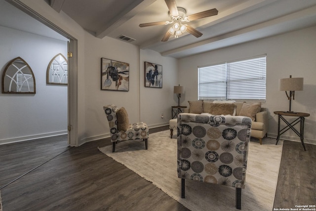 living area with ceiling fan, visible vents, wood finished floors, baseboards, and beamed ceiling
