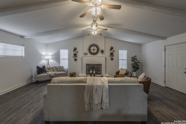 living area featuring ceiling fan, dark wood-style flooring, a brick fireplace, baseboards, and lofted ceiling with beams